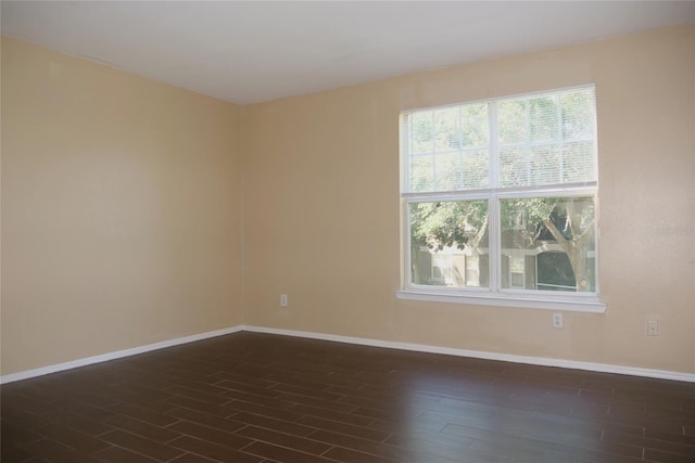 unfurnished room featuring dark wood-type flooring and baseboards
