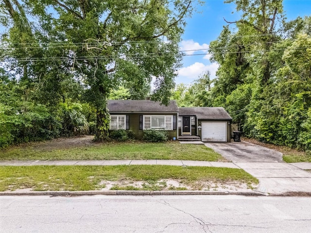 ranch-style home featuring an attached garage, driveway, and a front lawn
