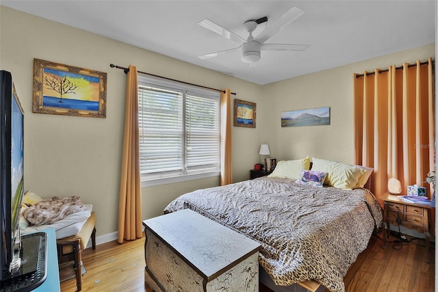 bedroom with light wood-style flooring, baseboards, and a ceiling fan