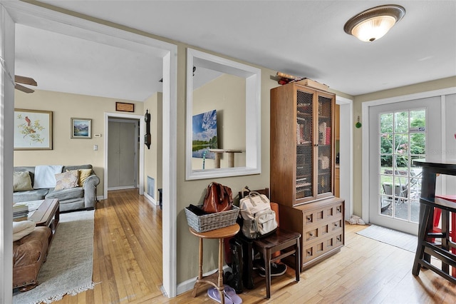 living area with hardwood / wood-style floors, baseboards, and a ceiling fan