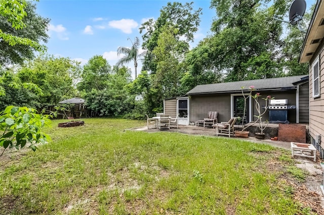 view of yard with a fire pit and a patio