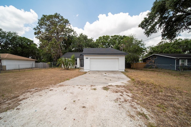 garage with driveway and fence