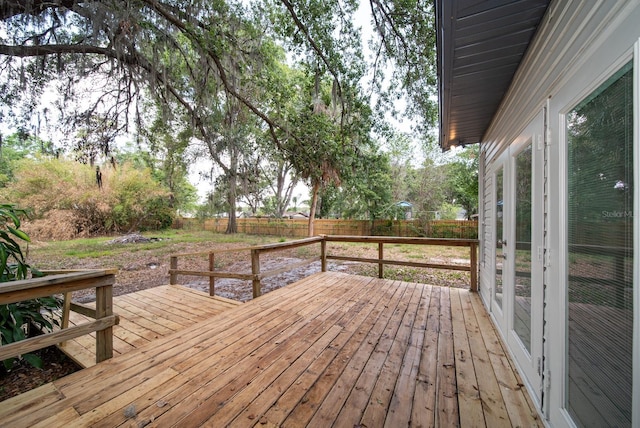 wooden terrace with a fenced backyard