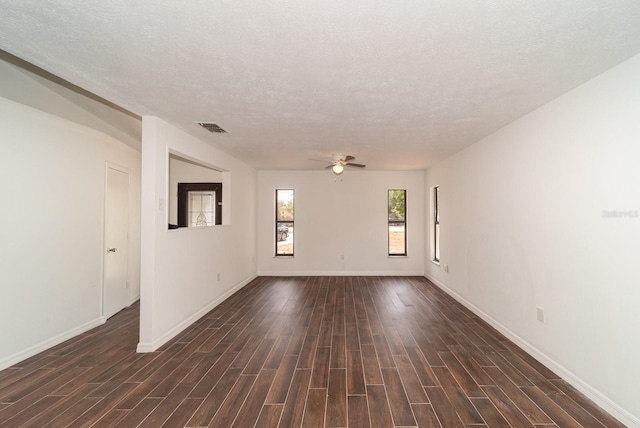 unfurnished room featuring dark wood-type flooring, a ceiling fan, baseboards, and a textured ceiling