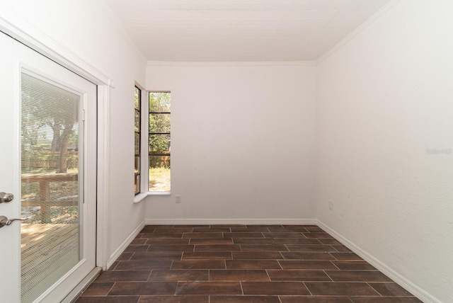 unfurnished room featuring crown molding, dark wood-style floors, and baseboards