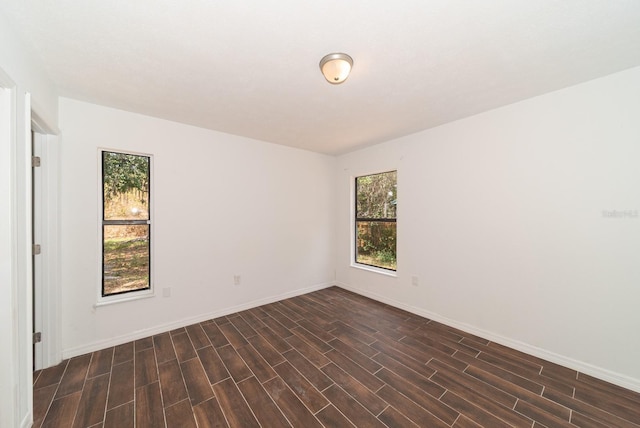 spare room with dark wood finished floors and baseboards