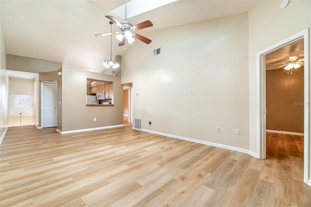 unfurnished living room with a ceiling fan, light wood finished floors, high vaulted ceiling, and baseboards