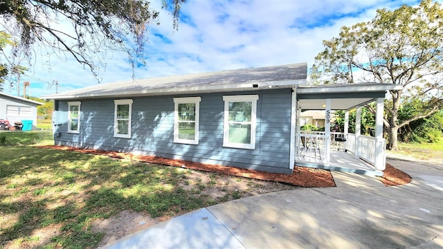 rear view of property featuring covered porch