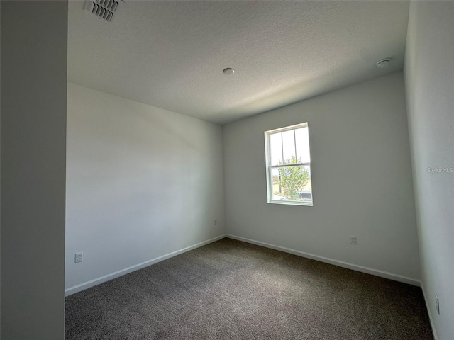 carpeted empty room with baseboards and a textured ceiling