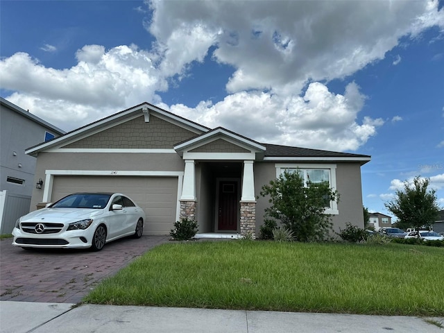 1141 Lakeshore Breeze Pl, Kissimmee, FL 34747 - craftsman-style house with decorative driveway, stucco siding, a garage, stone siding, and a front yard
