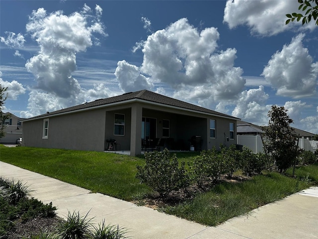 1141 Lakeshore Breeze Pl, Kissimmee, FL 34747 - view of side of home with stucco siding, a yard, and a patio