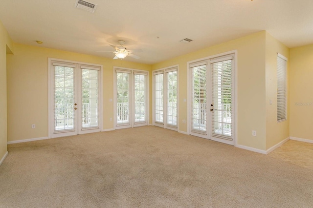 carpeted spare room featuring ceiling fan and baseboards