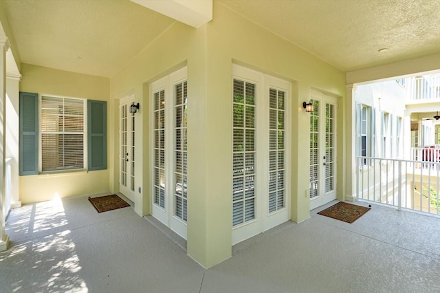 unfurnished sunroom with a textured ceiling and french doors