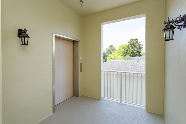 doorway with elevator and carpet flooring