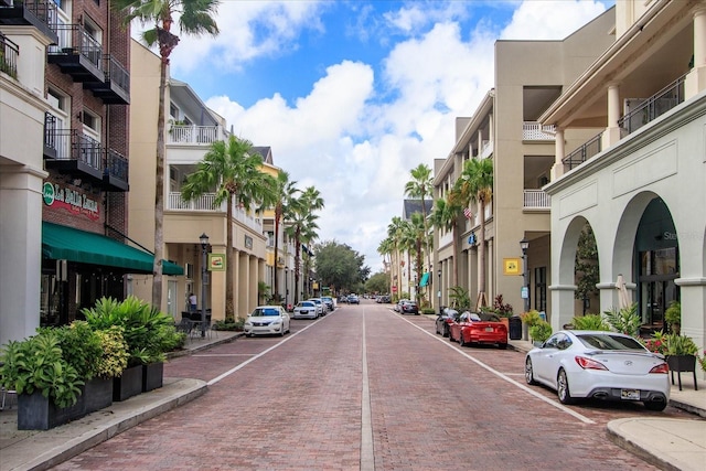 view of decorative road with street lights, curbs, and sidewalks