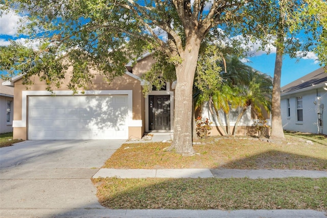 2643 Alamosa Pl, Lake Mary, FL 32746 - view of property hidden behind natural elements with a garage, concrete driveway, and stucco siding