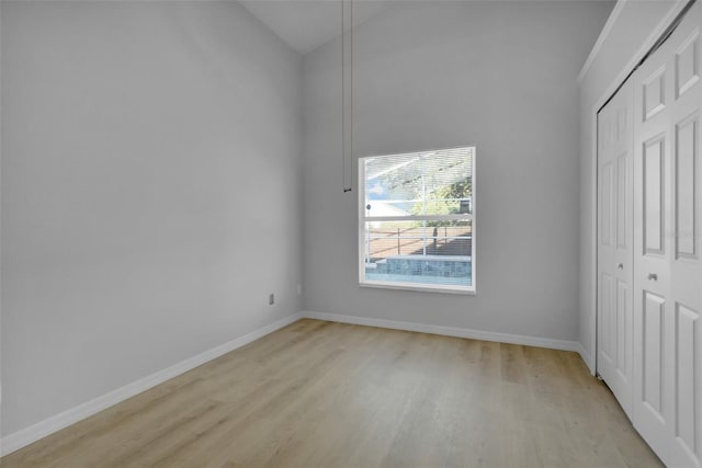 2643 Alamosa Pl, Lake Mary, FL 32746 - unfurnished bedroom with light wood finished floors, a closet, baseboards, and vaulted ceiling