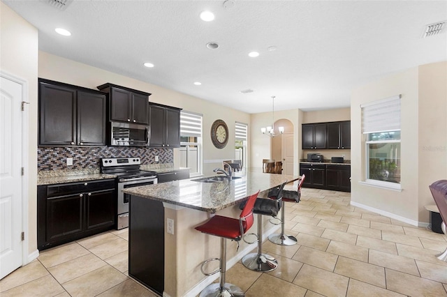 2136 J Lawson Blvd, Orlando, FL 32824 - kitchen with appliances with stainless steel finishes, a sink, light stone counters, tasteful backsplash, and light tile patterned floors