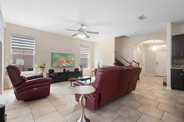 2136 J Lawson Blvd, Orlando, FL 32824 - living area featuring arched walkways, a ceiling fan, stairs, and light tile patterned flooring