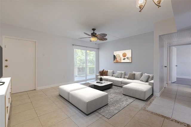 living room with ceiling fan, light tile patterned floors, and baseboards