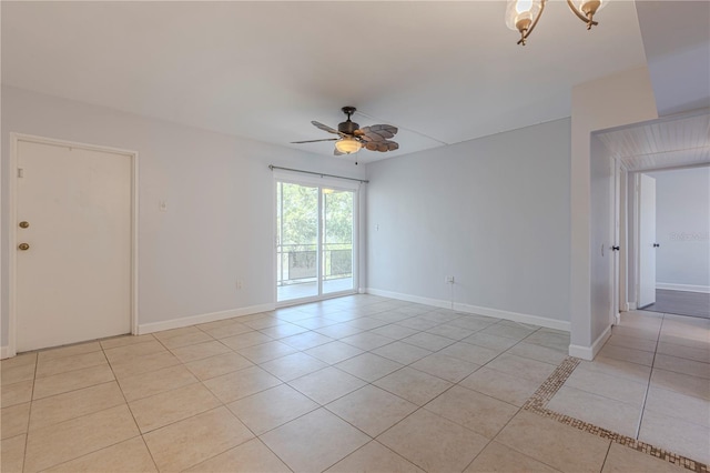 empty room featuring light tile patterned floors, ceiling fan, and baseboards