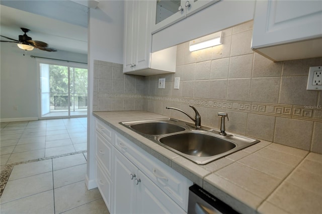 kitchen featuring tile counters, a sink, white cabinetry, and ceiling fan