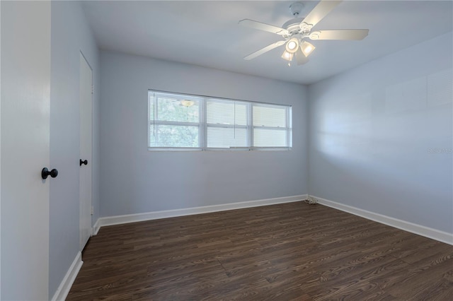 spare room with dark wood finished floors, baseboards, and a ceiling fan