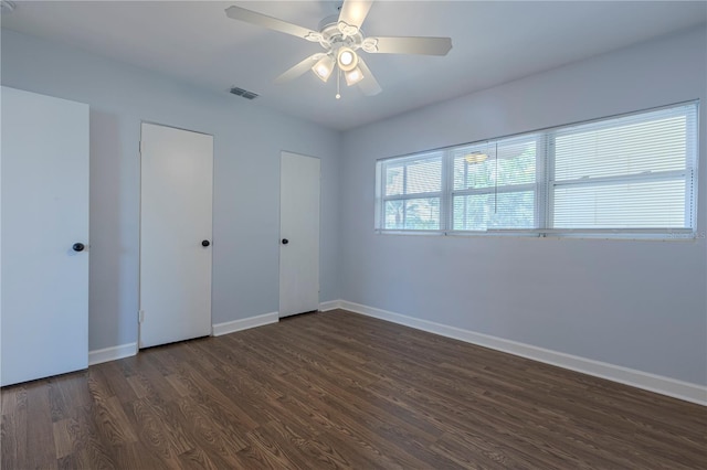 unfurnished bedroom with dark wood-style floors, baseboards, and ceiling fan