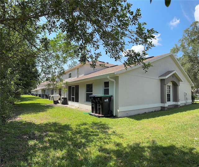 14844 Laguna Beach Cir, Orlando, FL 32824 - rear view of property with a yard, central AC, and stucco siding