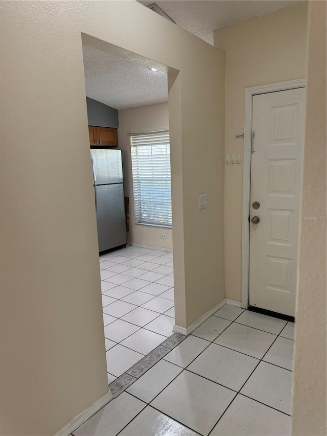 14844 Laguna Beach Cir, Orlando, FL 32824 - foyer entrance with a textured ceiling, light tile patterned flooring, and baseboards