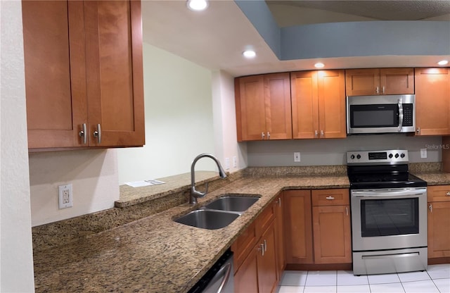 14844 Laguna Beach Cir, Orlando, FL 32824 - kitchen with appliances with stainless steel finishes, a sink, brown cabinets, recessed lighting, and dark stone counters