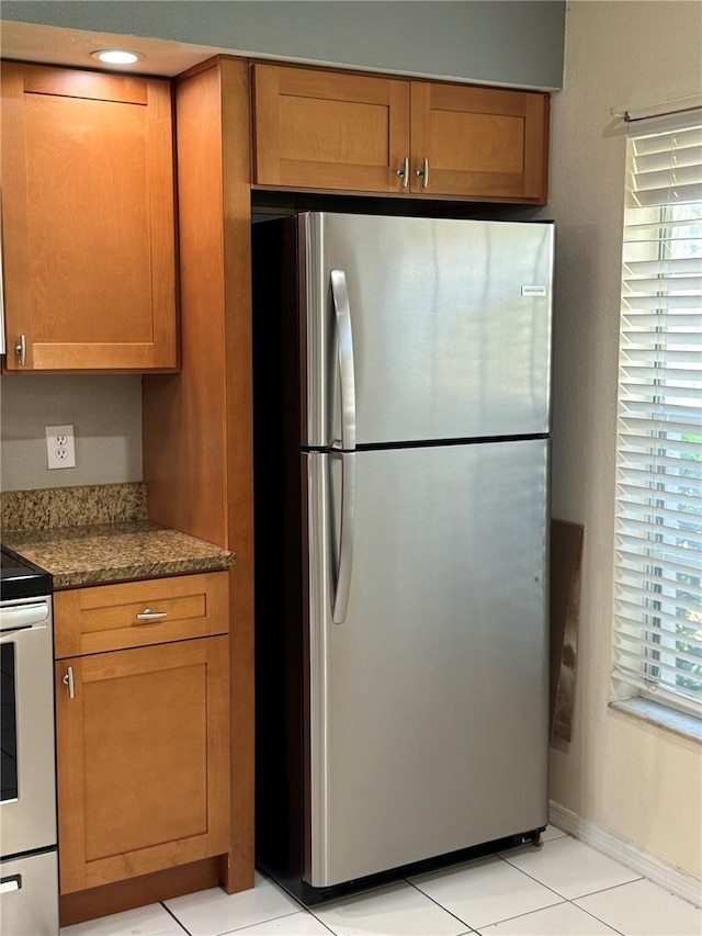 14844 Laguna Beach Cir, Orlando, FL 32824 - kitchen with freestanding refrigerator, range with electric cooktop, and brown cabinets
