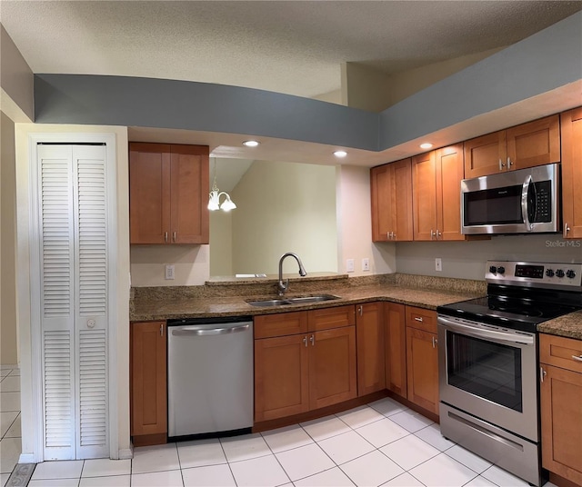 14844 Laguna Beach Cir, Orlando, FL 32824 - kitchen featuring stainless steel appliances, a sink, brown cabinets, recessed lighting, and light tile patterned floors
