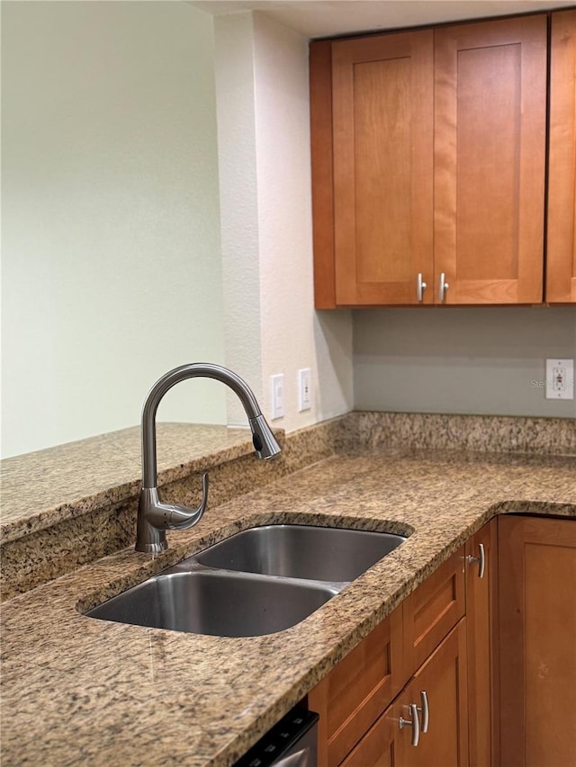 14844 Laguna Beach Cir, Orlando, FL 32824 - kitchen featuring a sink, brown cabinets, and light stone counters