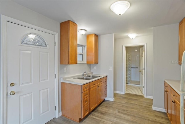 408 Eunice Dr, Plant City, FL 33563 - kitchen featuring a sink, light countertops, baseboards, and brown cabinetry