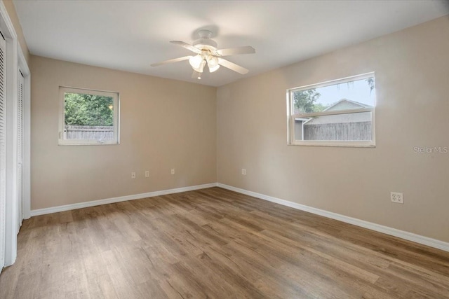 408 Eunice Dr, Plant City, FL 33563 - unfurnished bedroom featuring multiple windows, wood finished floors, baseboards, and a closet