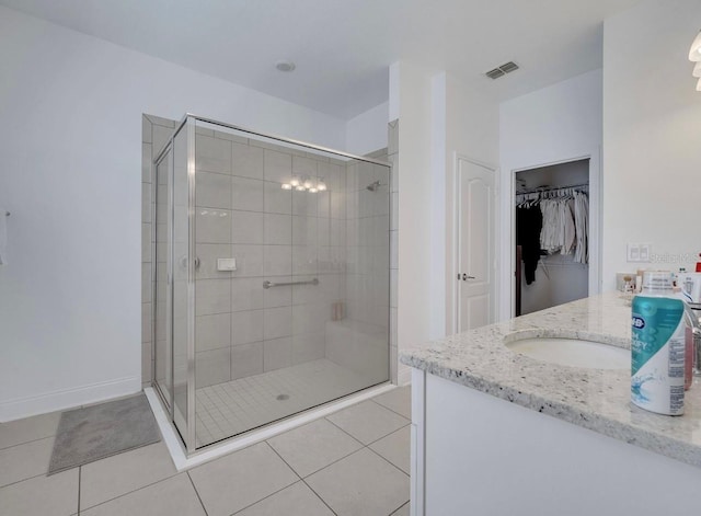 bathroom featuring a stall shower, tile patterned flooring, a walk in closet, and vanity