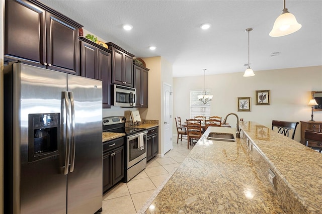 1286 Tallow Rd, Apopka, FL 32703 - kitchen featuring appliances with stainless steel finishes, a sink, light tile patterned floors, hanging light fixtures, and a chandelier