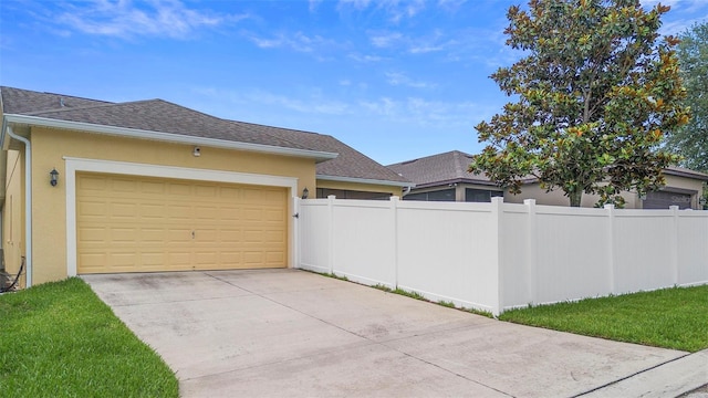 1286 Tallow Rd, Apopka, FL 32703 - view of home's exterior with stucco siding, fence, driveway, a garage, and roof with shingles