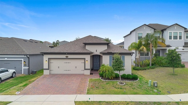 view of front of home featuring stucco siding, an attached garage, decorative driveway, and a front lawn