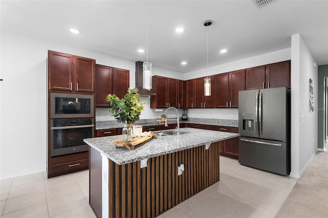 kitchen featuring stainless steel appliances, wall chimney range hood, a sink, light stone countertops, and recessed lighting