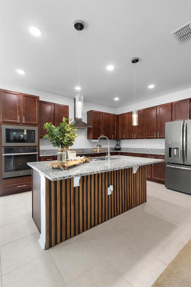 kitchen with appliances with stainless steel finishes, wall chimney exhaust hood, a sink, light stone counters, and recessed lighting