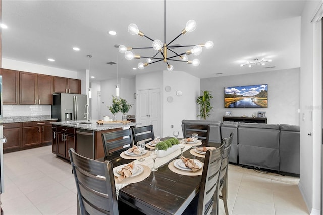 dining area featuring light tile patterned flooring, recessed lighting, and a chandelier