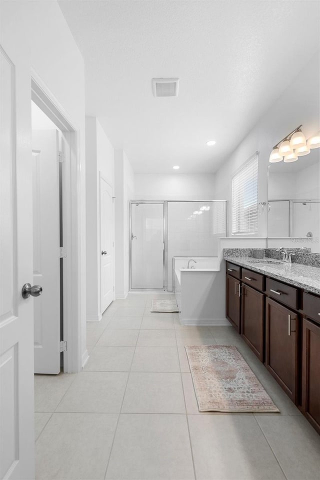 bathroom featuring tile patterned flooring, a stall shower, vanity, and a bath