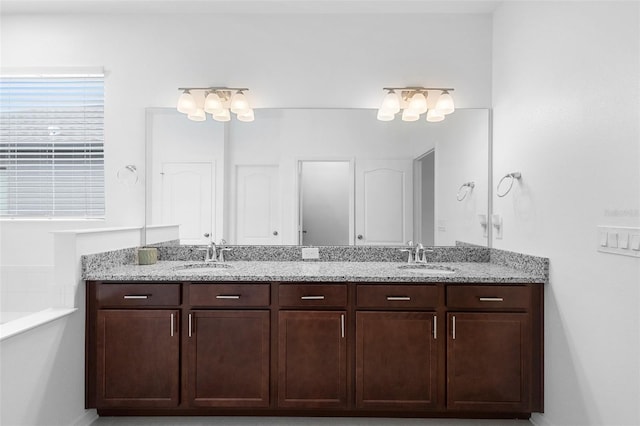 bathroom with double vanity and a tub to relax in