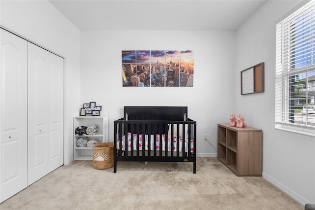 bedroom featuring carpet flooring, a closet, a crib, and baseboards