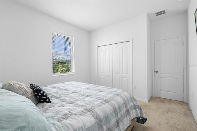 bedroom featuring light colored carpet, a closet, and baseboards