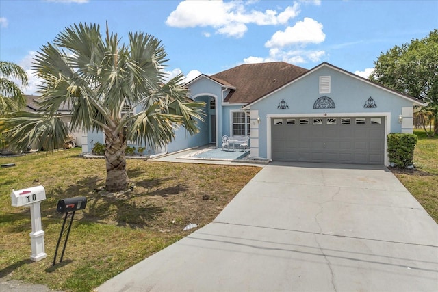view of front of property featuring stucco siding, a garage, concrete driveway, and a front yard