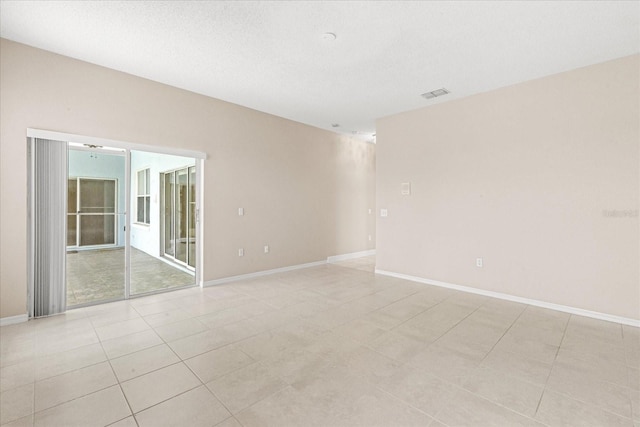 empty room featuring baseboards and light tile patterned flooring