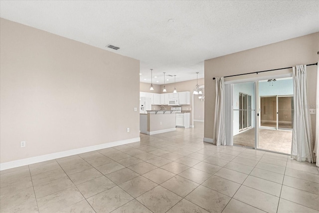 unfurnished living room featuring light tile patterned floors, baseboards, a textured ceiling, and recessed lighting